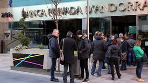 Colas ante una oficina de la Banca Privada d’Andorra en Escaldes, este lunes.