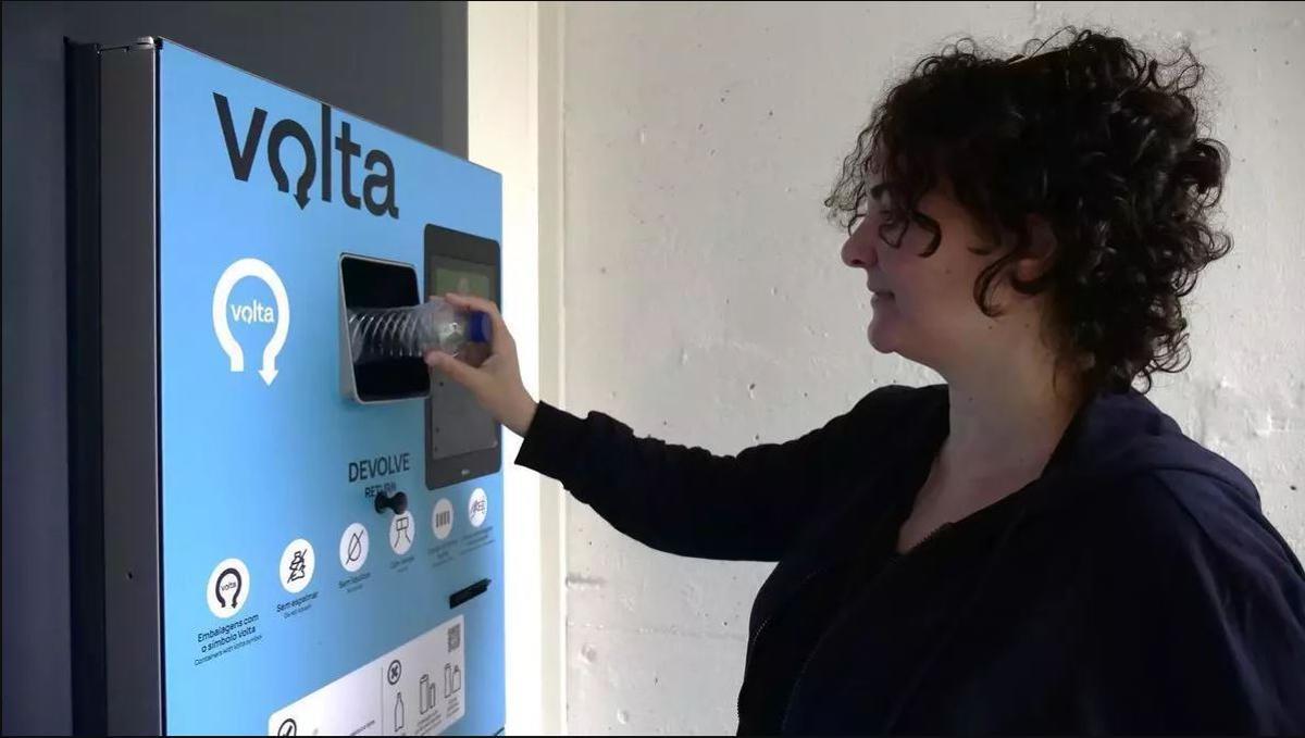 Una mujer devuelve una botella.
