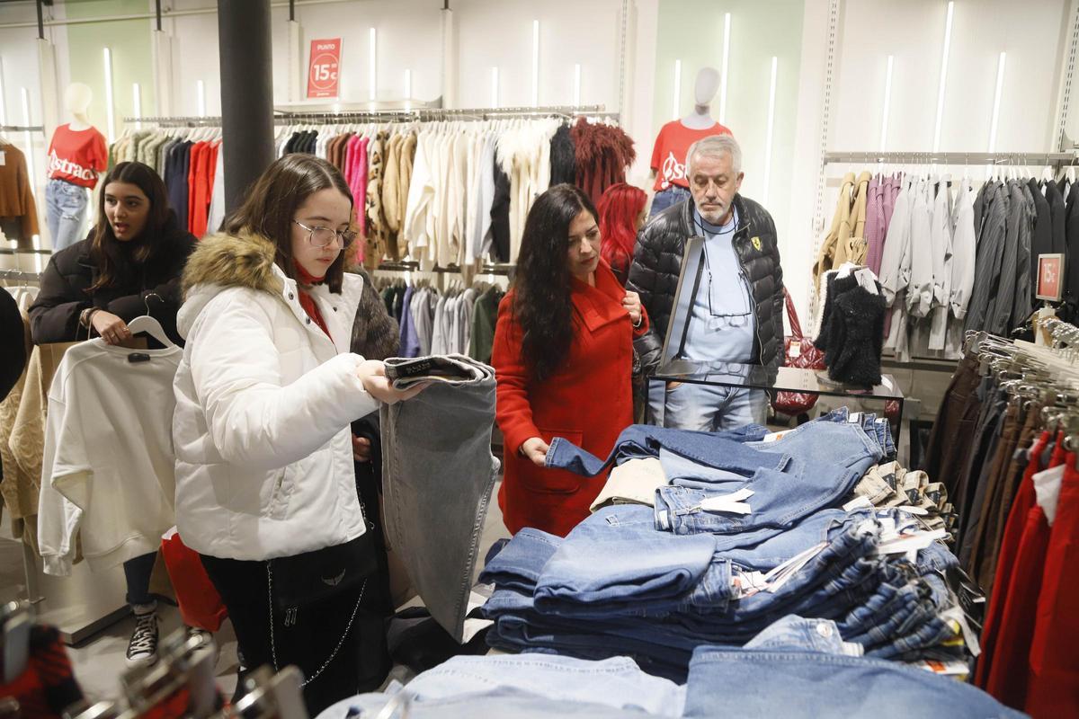 Clientes observan los productos en una tienda de ropa.