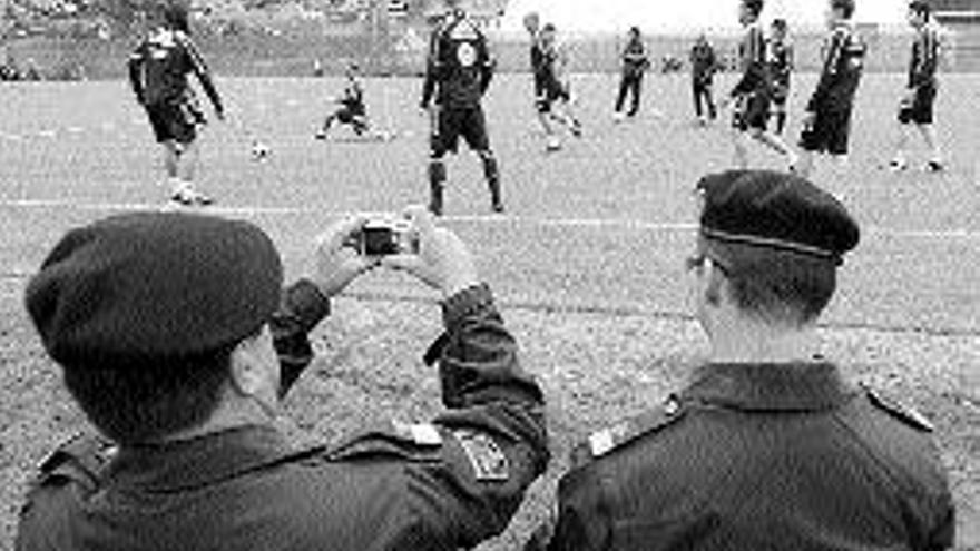 Dos policías hacen fotos a los jugadores de la selección. / Efe