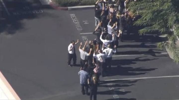 A still image from a video footage courtesy of Nbcla.com shows people lining up as first responders respond to shooting in San Bernardino California