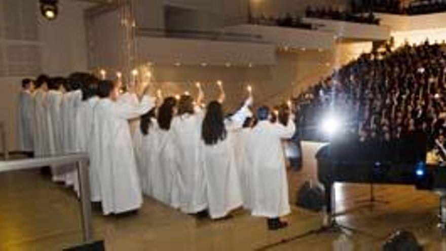 Los niños del coro de la Escolanía del Misteri iluminan con sus velas, que fueron encendiendo a medida que cantaban, la sala sinfónica del ADDA, donde los asistentes escucharon emocionados la interpretación