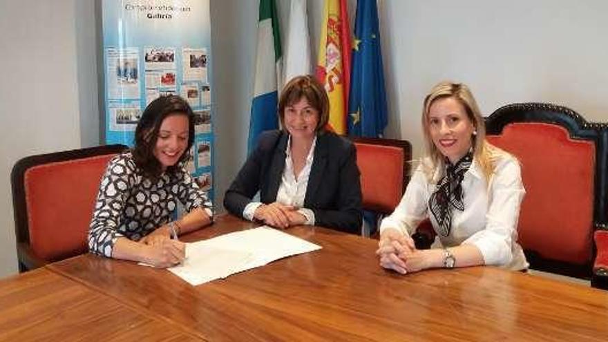 La alcaldesa, Mª Carmen Alonso (centro), en la firma del convenio con la directora de CaixaBank en O Rosal. // D.B.M.