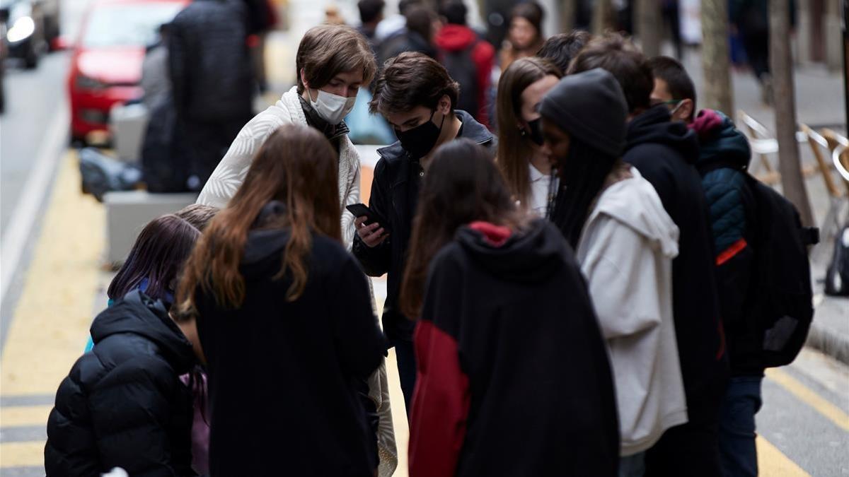 Varios jóvenes conversan en una calle de Barcelona