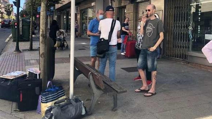 Vecinos con maletas en la calle, el sábado, a la espera de trasladarse a hoteles o a casas de familiares. // FdV