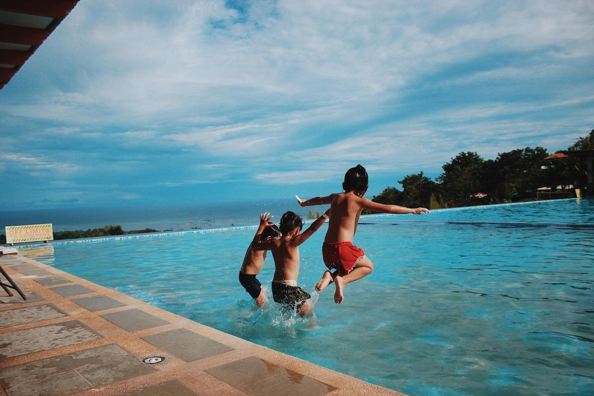 Unos niños jugando en la piscina del apartamento de la playa