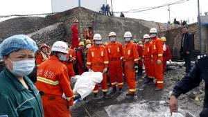 Unos rescatistas chinos trasladan un cadáver tras un accidente en una mina en 2018.