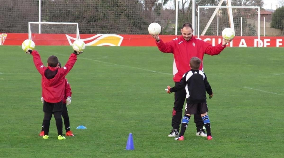 Un técnico, con niños de la Escuela de Fútbol del Mareo.