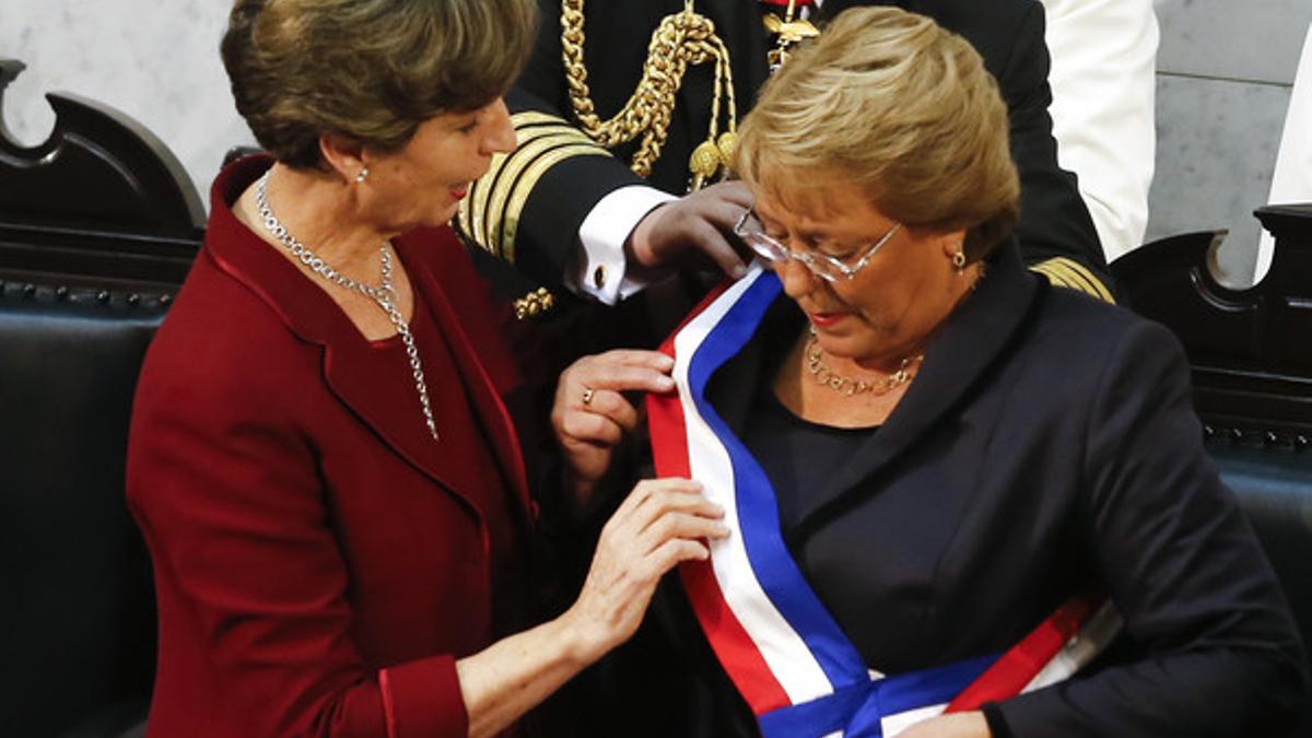 Isabel Allende, hija del presidente derrocado por la dictadura de Pinochet, coloca la banda presidencial a Michelle Bachelet, hija de un militar leal a Allende.