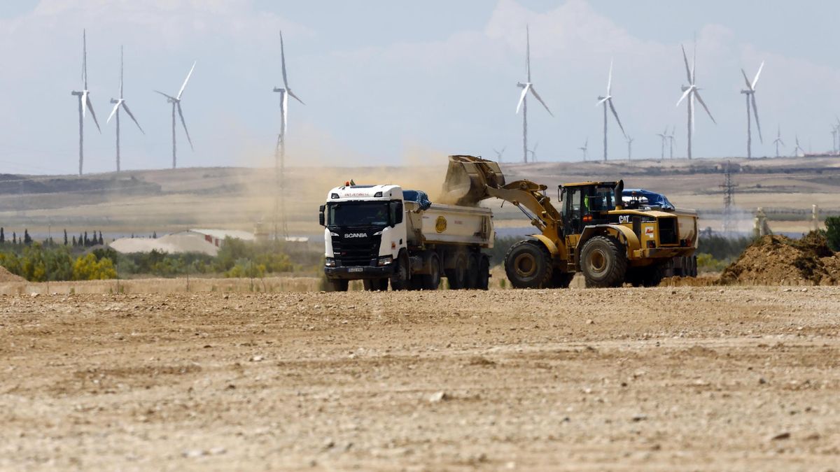 Movimiento de tierras en los suelos donde se levantará la gigafactoría de Figueruelas, con un parque eólico al fondo.