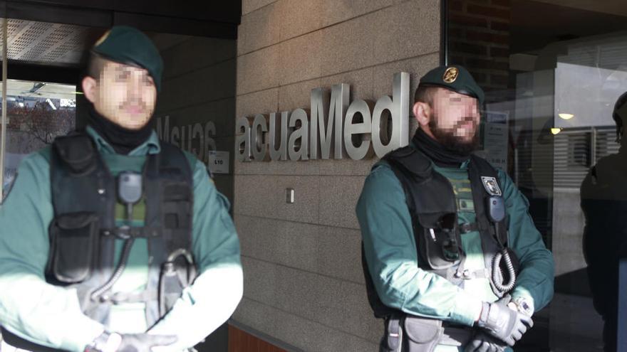 Dos agentes de la Guardia Civil, ayer apostados en la puerta de la sede de Aguas de las Cuencas Mediterráneas (Acuamed), mientras se llevaba a cabo el registro de sus dependencias