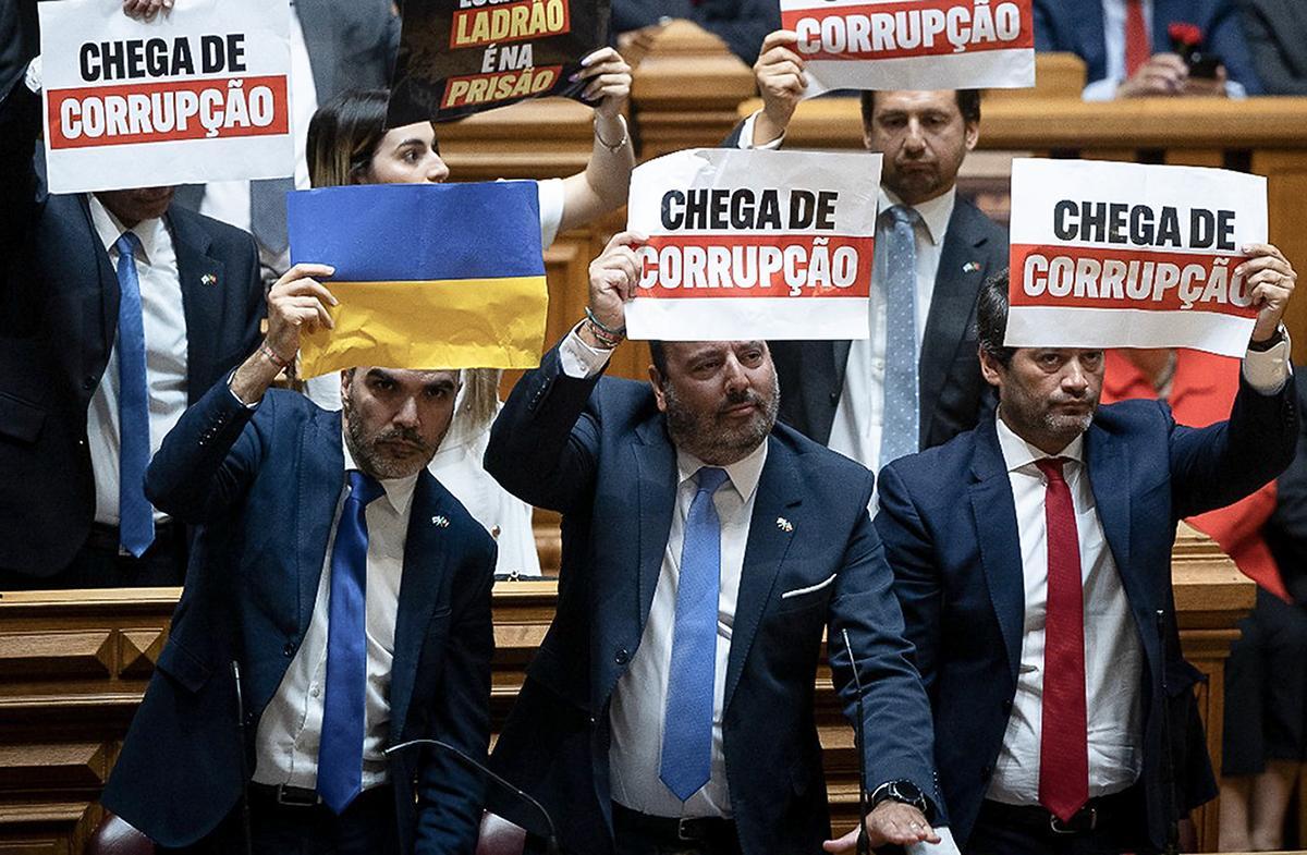 Diputados del grupo ultra Chega muestran carteles en los que se lee &quot;Basta de corrupción&quot; durante la ceremonia de bienvenida a Lula da Silva, este martes en el Parlamento portugués.