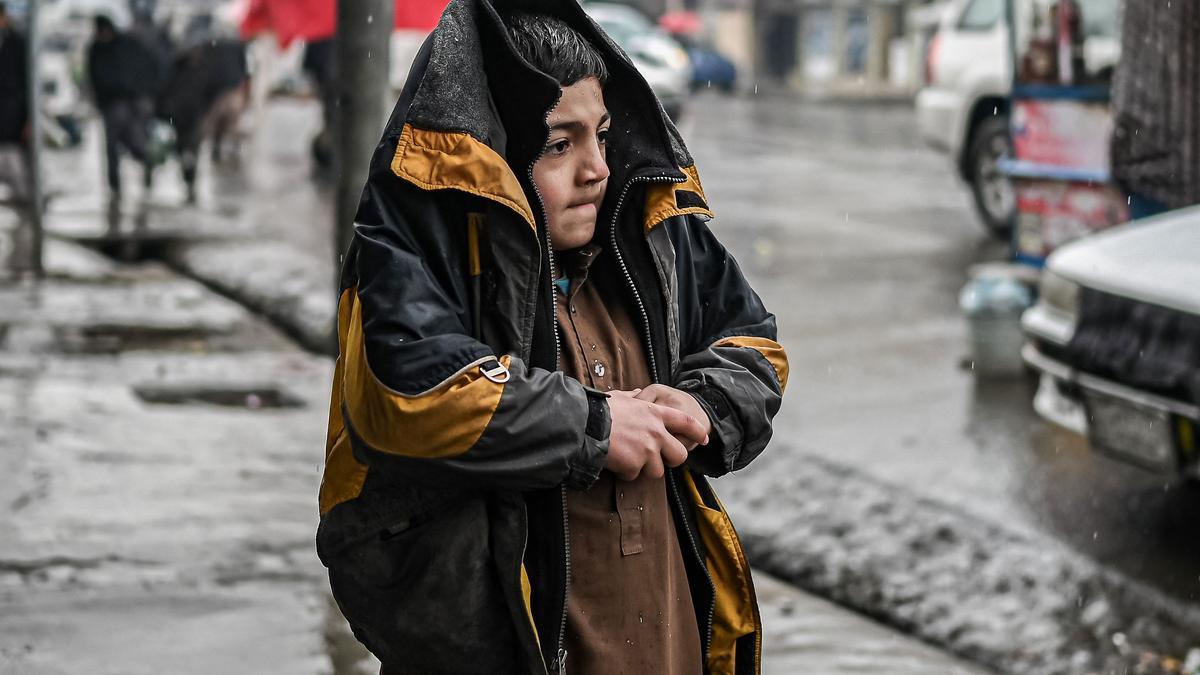 Un niño afgano se protege del frío mientras camina por una calle de Kabul, el pasado 1 de enero.