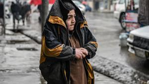 Un niño afgano se protege del frío mientras camina por una calle de Kabul, el pasado 1 de enero.