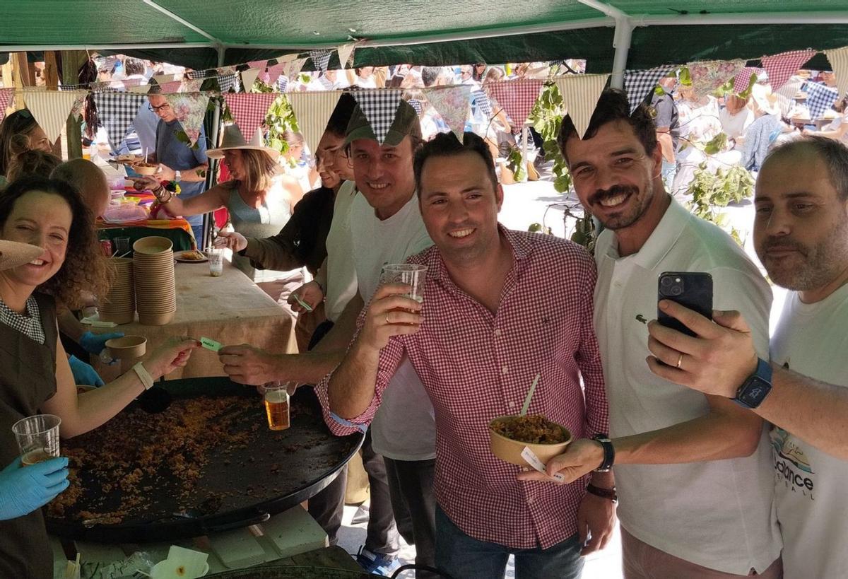 Loreto reparte paella a Carlos, Tomás, Pablo y Michu, desde el puesto de arroces.