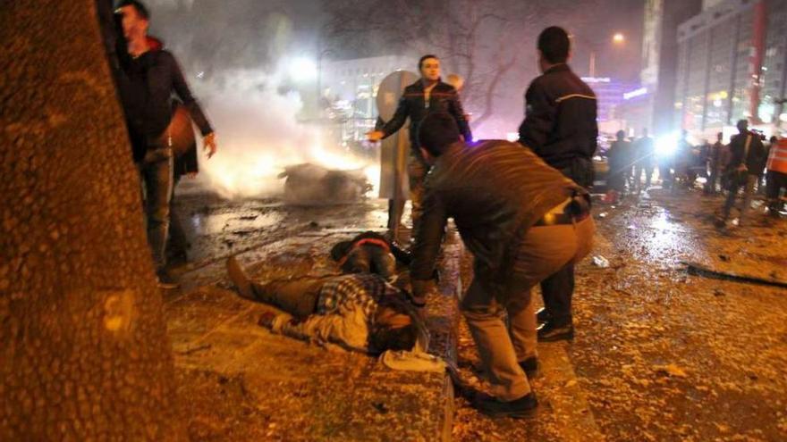 Dos personas yacen en el suelo tras la explosión de Ankara. // Reuters