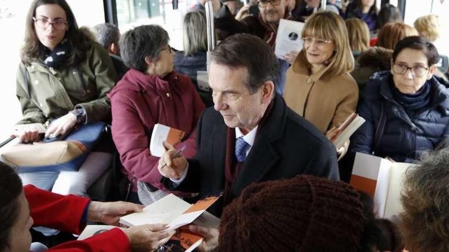 Caballero firma uno de los libros que entregó durante el trayecto en bus. // Alba Villar