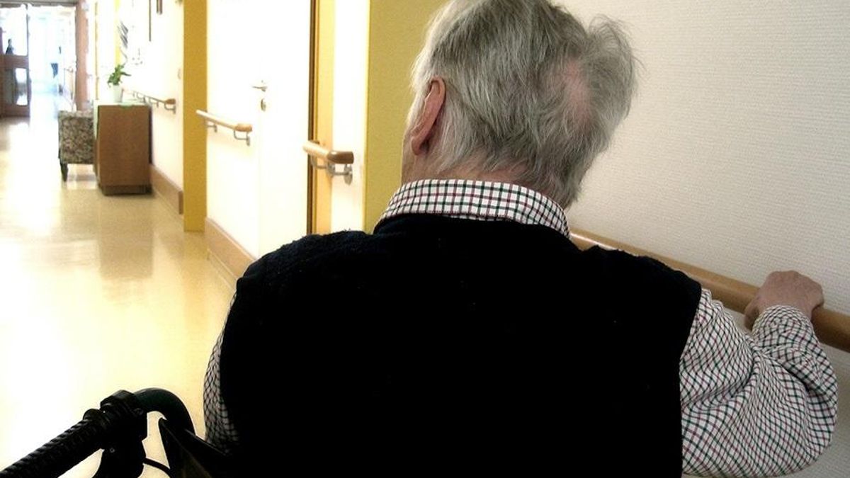 Una persona en silla de ruedas se desplaza por los pasillos de una residencia de mayores.