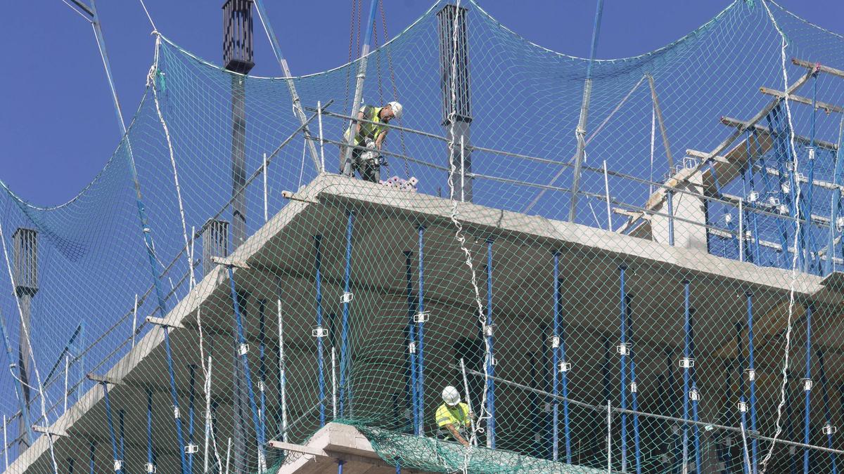 Varios obreros trabajan en la construcción de un edificio residencial.