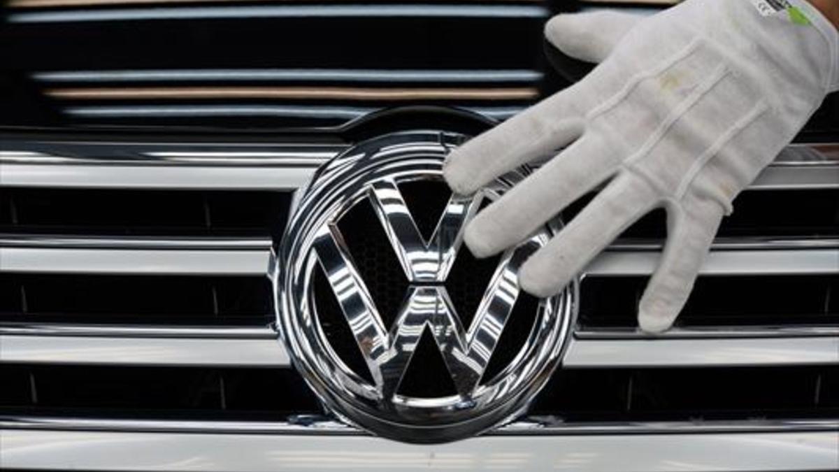 Marca 8Un empleado coloca el logotipo de Volkswagen a un vehículo.