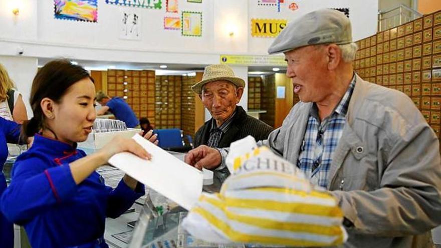 Un usuari és atès per una funcionària de correus a Ulan Bator