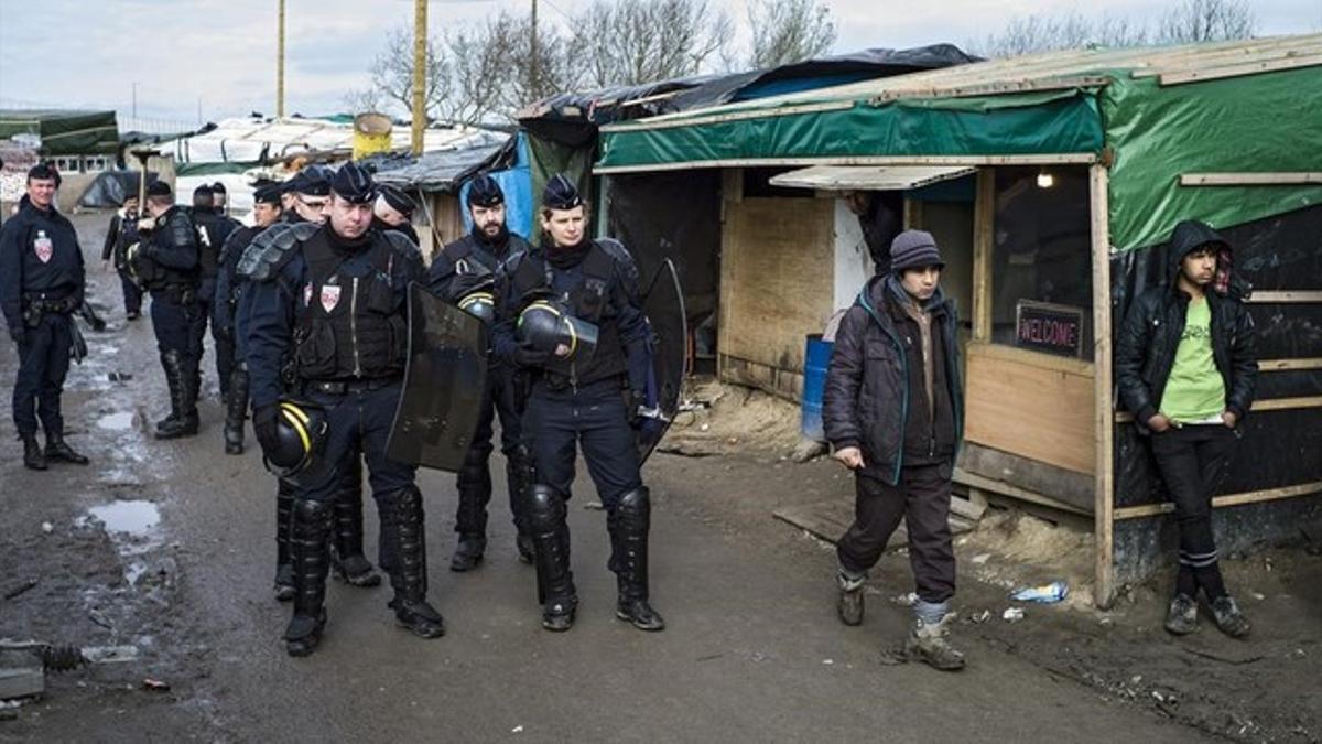 Agentes de seguridad patrullan el campamento conocido como la 'jungla' de Calais que fue desmantelado.