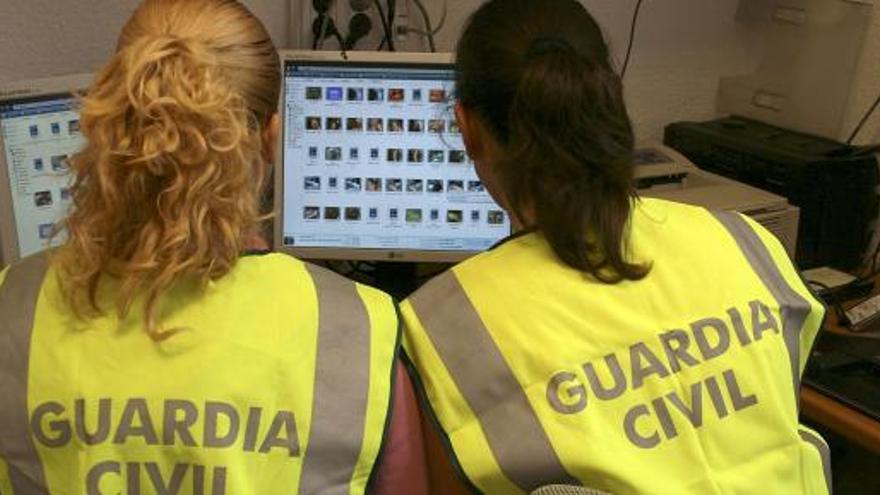 Dos agentes de la Guardia Civil, en una operación contra delitos en Internet.