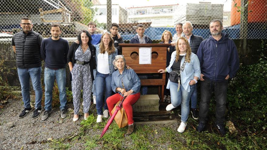 Voluntarios, representantes del Losada Diéguez y el edil Juan Constenla posan ante una de las casas de madera.  | // BERNABÉ/JAVIER LALÍN