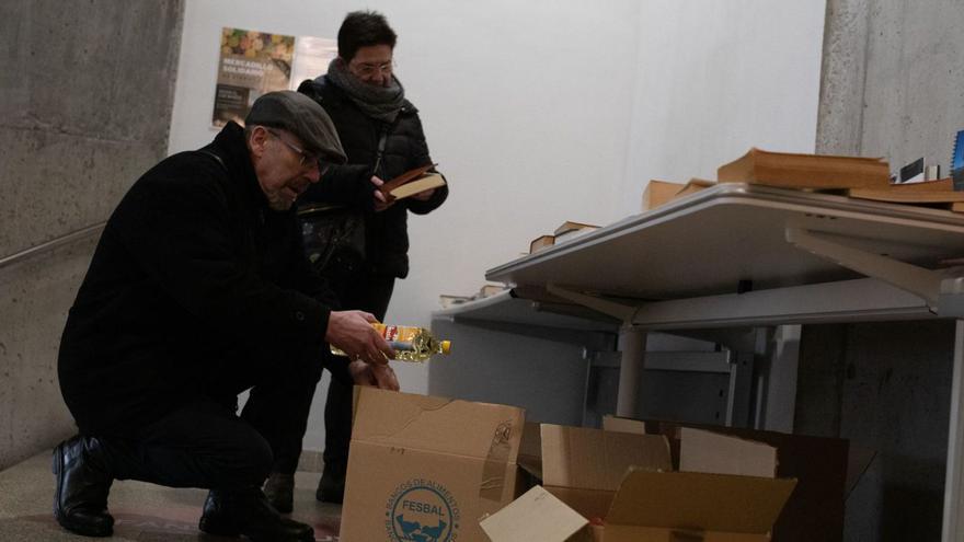 Una pareja elige un libro y deja una botella de aceite.