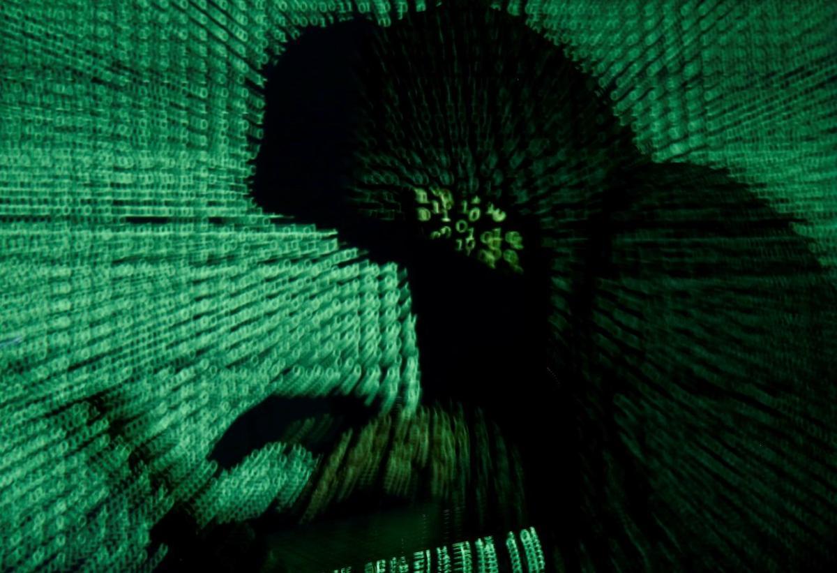 FILE PHOTO  A man holds a laptop computer as cyber code is projected on him in this illustration picture taken on May 13  2017  Capitalizing on spying tools believed to have been developed by the U S  National Security Agency  hackers staged a cyber assault with a self-spreading malware that has infected tens of thousands of computers in nearly 100 countries  REUTERS Kacper Pempel Illustration File Photo