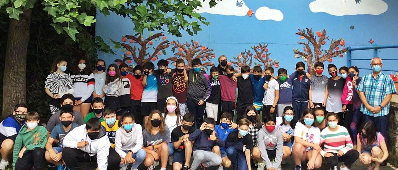 Los niños del colegio San Félix, ante el panel cerámico “Pumarada” instalado en el centro.  | LNE