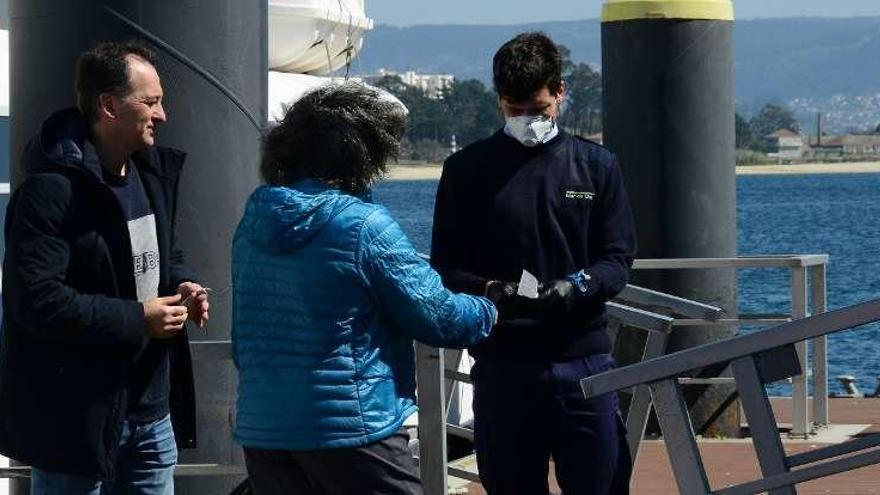 Dos usuarios entrando ayer en el barco de las 14:00 horas en Cangas. // Gonzalo Núñez