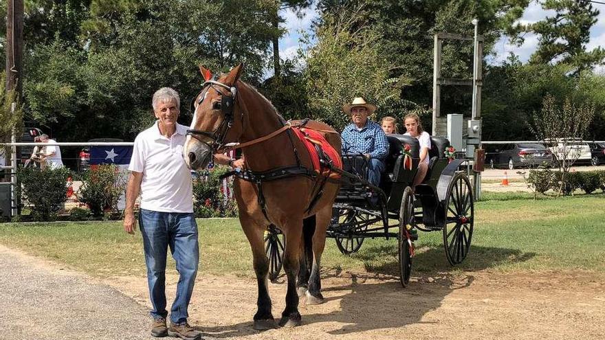 Antonio Renilla (de pie) junto a uno de los carruajes que llevaban de paseo a los asistentes.