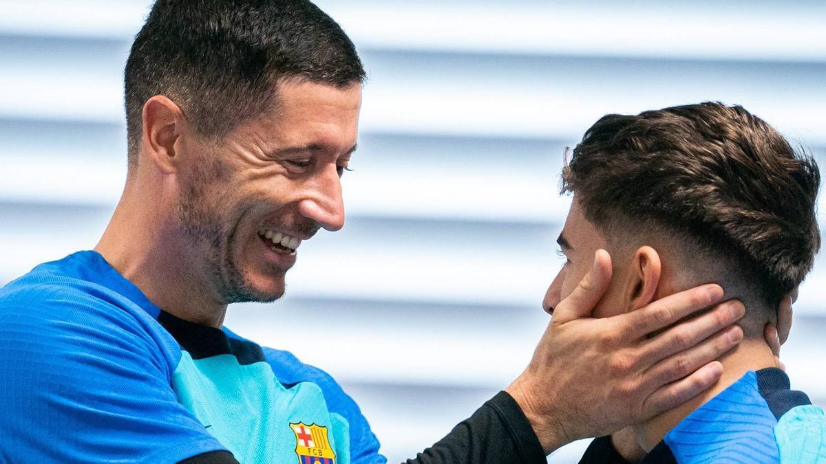 Lewandowski y Gavi se saludan en el entrenamiento de este lunes.