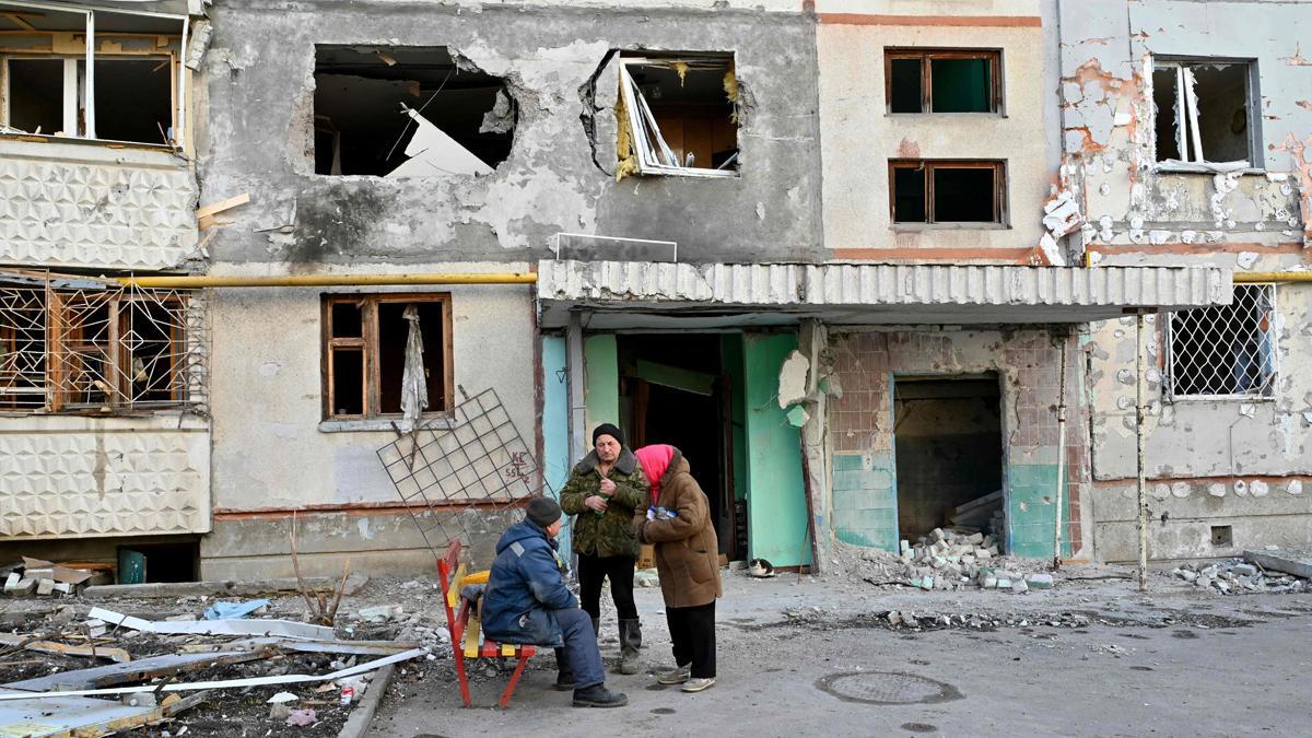 Los ancianos hablan fuera de su edificio residencial en Kharkiv el 29 de marzo de 2022, parcialmente destruido por el bombardeo de las tropas rusas