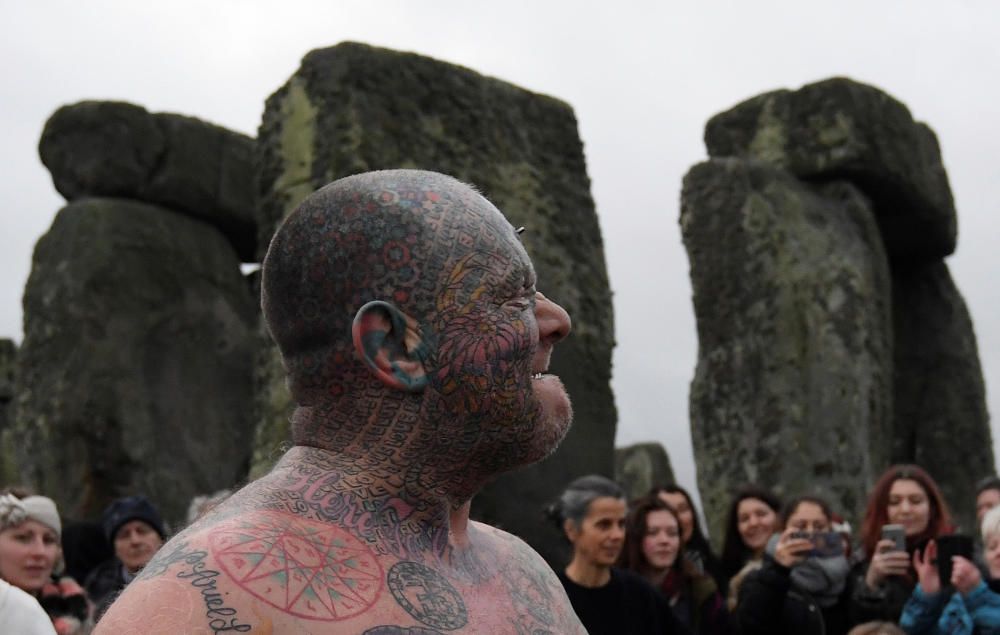 Miles de personas, varias de ellas disfrazadas de druidas, acudieron hoy al monumento de Stonehenge en Inglaterra para ver el amanecer con motivo del solsticio de invierno.