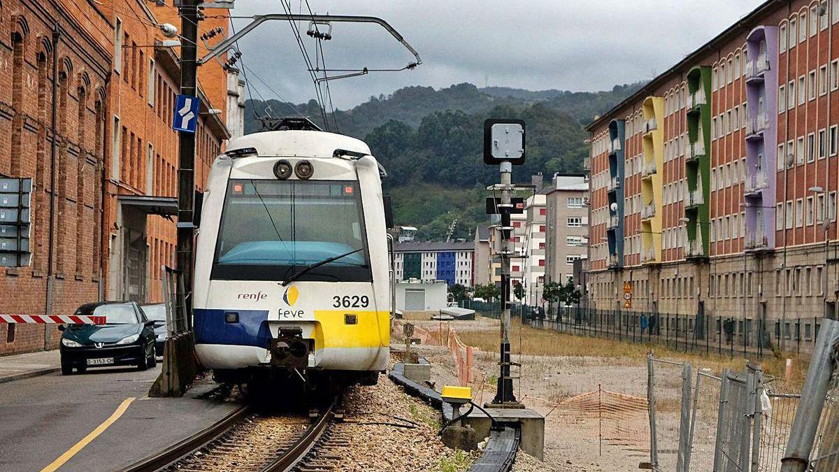 El tren circula junto a la zona donde se construyó el falso túnel, en La Felguera.