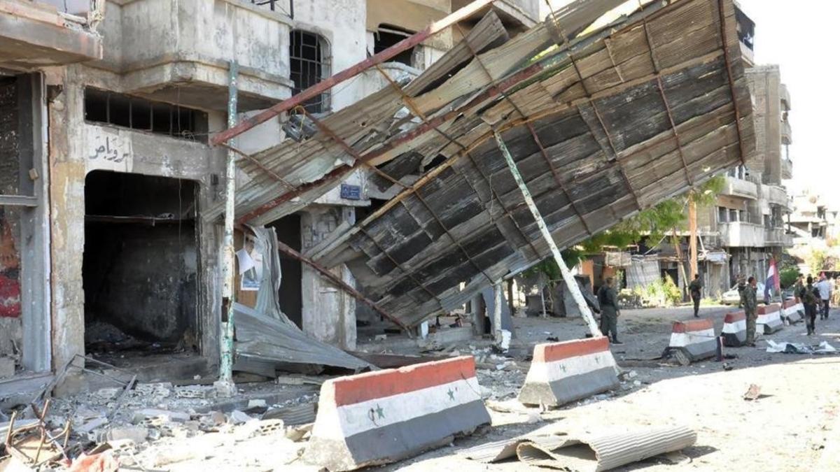 Soldados del Ejército sirio inspeccionan el daño causado por un coche bomba en la ciudad de Homs, en el centro de Siria, el lunes por la mañana.