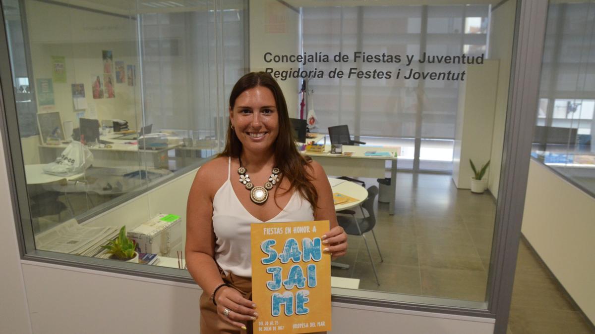 La concejala de Fiestas, Jennifer Casañ, posa junto al carte de las fiestas de San Jaime de 2022.