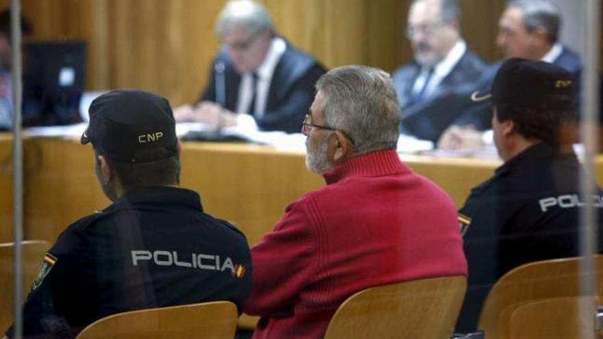 El narco Laureano Oubiña, ayer, durante el juicio en la Audiencia Nacional, entre dos policías. / efe