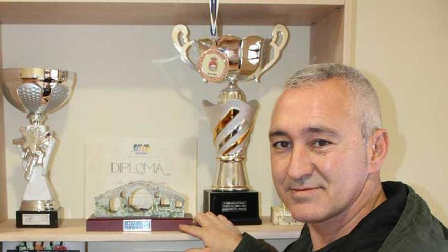 Chus Rodríguez, junto a los trofeos de la peña de bolos de El Berrón.