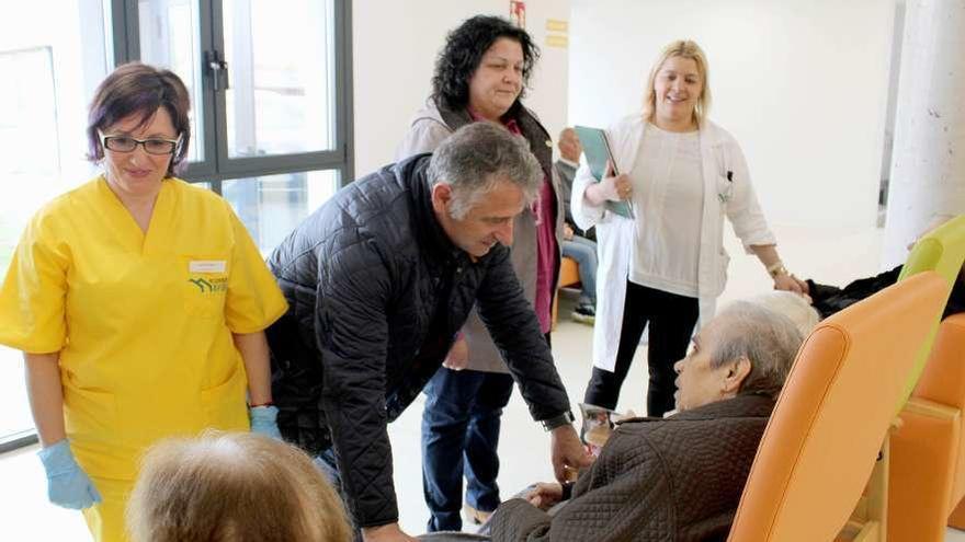 Manuel Cuíña saluda a una usuaria, en presencia de Pilar Peón y Paula Guzmán.