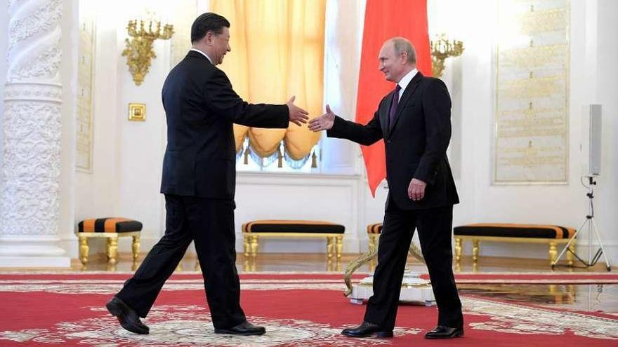Saludo entre Xi (izq.) y Putin, ayer, en el Kremlin. // DPA
