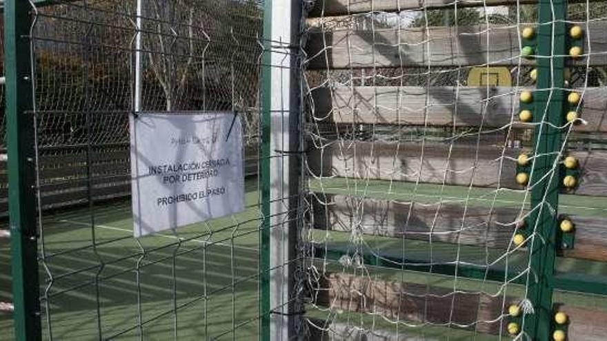 El cartel de zona cerrada por deterioro en la cancha de fútbol del parque Maestro Antuña de Candás.