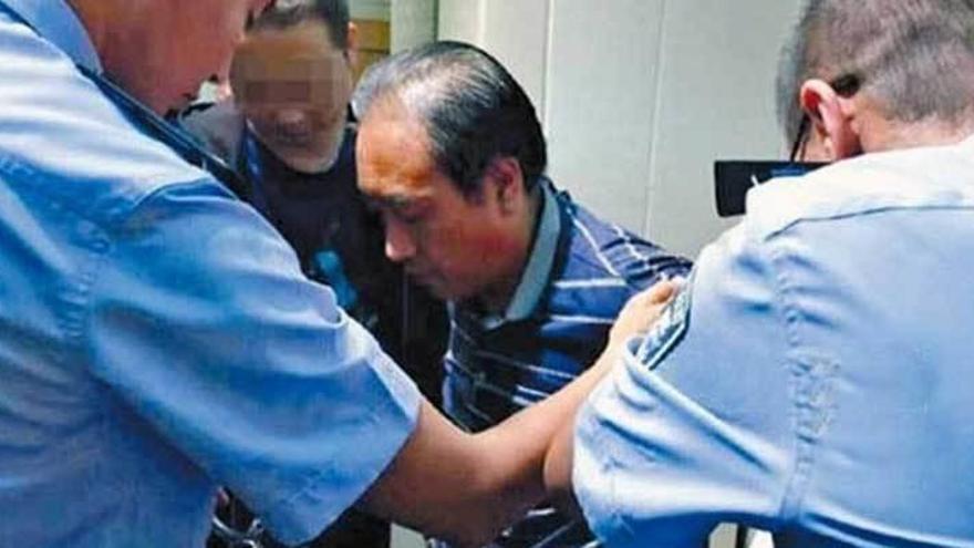 Gao Chengyong, rodeado de policías.