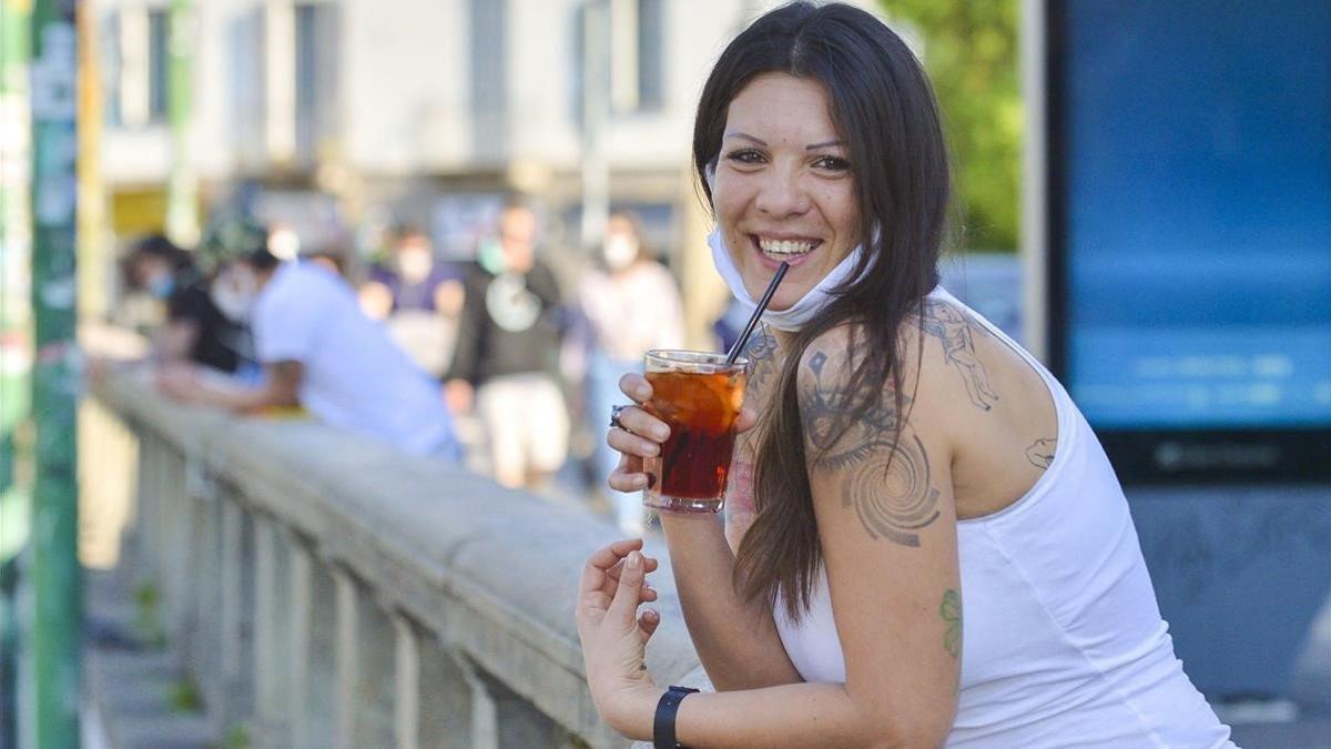 Una mujer toma un cocktail en Milán.