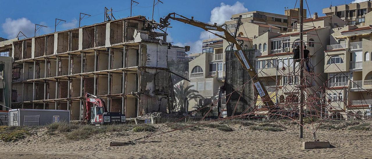 Una pala derribando este martes el piso superior del hotel de Arenales del Sol. | ANTONIO AMORÓS