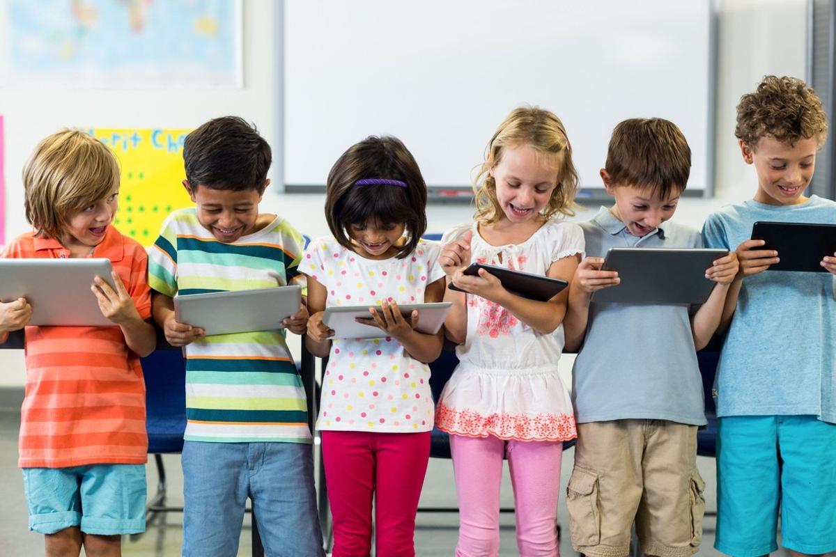 Varios niños con tabletas. 