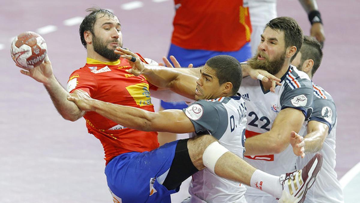 Cañellas trata de superar a Luka Karabatic y Narcisse en la semifinal ante Francia, en Catar