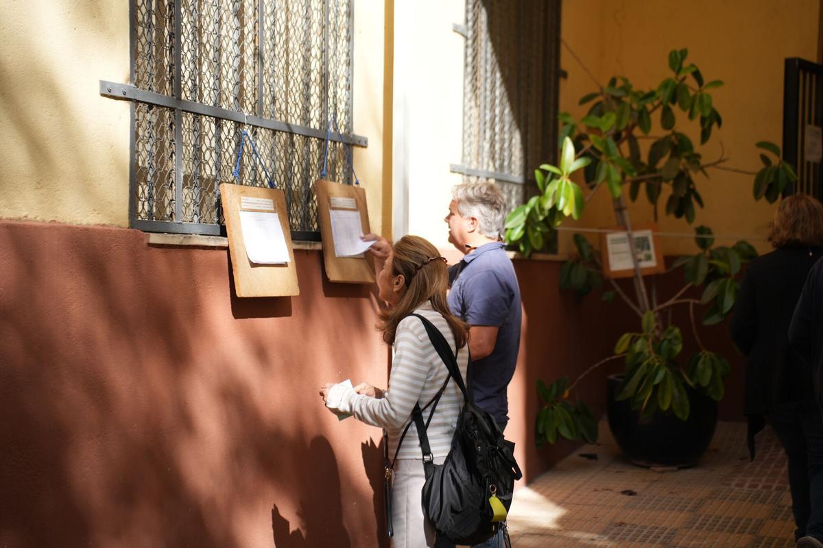 Electores comprueban sus datos a la entrada de una de las mesas electorales en la capital cordobesa, esta mañana.
